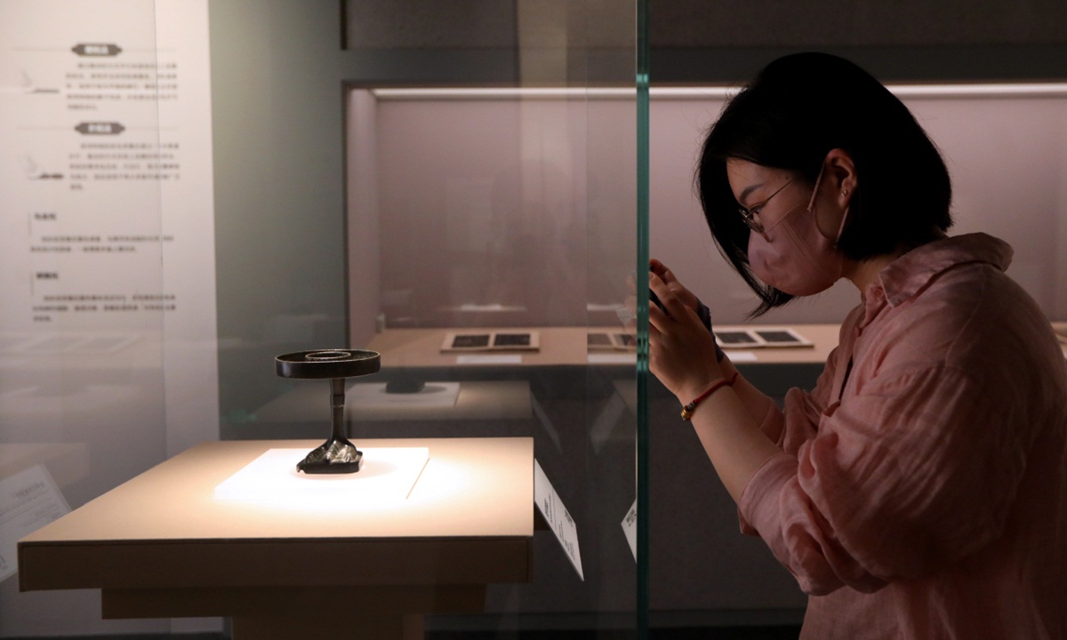 A visitor takes a photo of the Goose Foot Lamp Made in the First Year of the Jingning Era. (Photo: Chen Xia/GT)