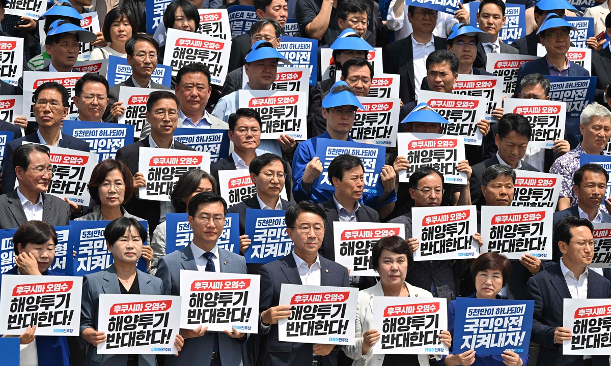 South Korea's main opposition Democratic Party lawmakers and party members hold placards reading We oppose the dumping of Fukushima contaminated water into the sea during a rally against Japan's plan to release treated water from the Fukushima nuclear plant, at the National Assembly in Seoul on July 7, 2023. Photo: VCG