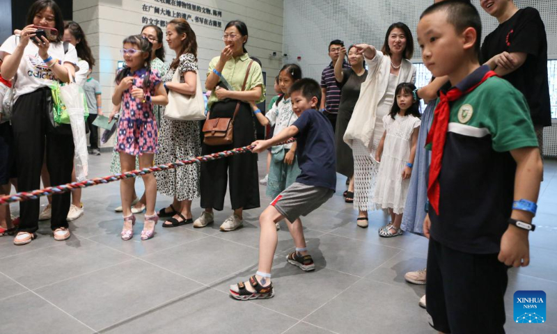 A boy takes part in a traditional tug-of-war game at a night fair at Minhang Museum of Shanghai in east China to experience the traditional Mongolian custom, July 21, 2023. (Xinhua/Xin Mengchen)