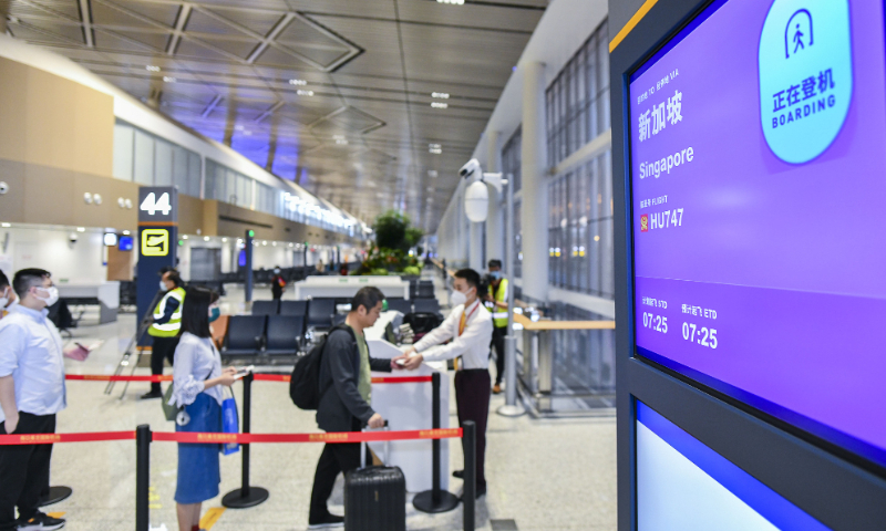 The picture taken on March 15, 2023, shows passengers queuing up for boarding Hainan Airlines flight HU747 from Haikou Meilan International Airport heading to Singapore. Photo: VCG