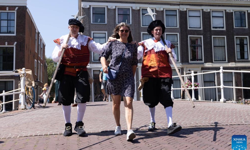 A visitor interacts with actors during the Rembrandt Days in Leiden, the Netherlands, July 8, 2023. During the two-day event, the city's historic center is transformed into 17th-century atmospheres to celebrate the life and work of Dutch painter Rembrandt van Rijn. Leiden is the birthplace of Rembrandt. (Photo by Sylvia Lederer/Xinhua)