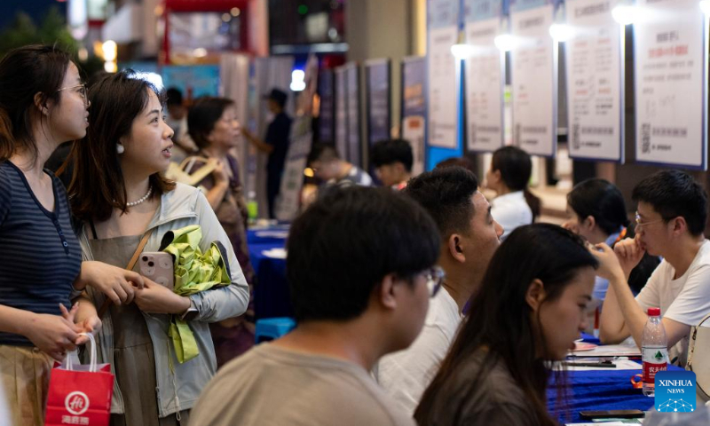 Job seekers read recruitment information at a job fair for college graduates in Jinhua City, east China's Zhejiang Province, July 21, 2023. (Photo by Shi Kuanbing/Xinhua)
