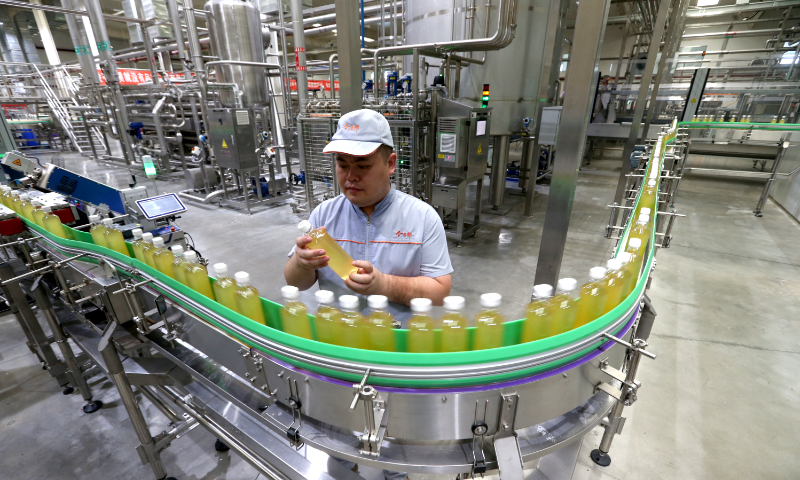 A worker samples bottled water at a factory in Meishan, Southwest China's Sichuan Province, on July 24, 2023. It's high season for bottled water in the summer, and food production enterprises in Meishan are working at full capacity to ensure market supply. Photo: VCG