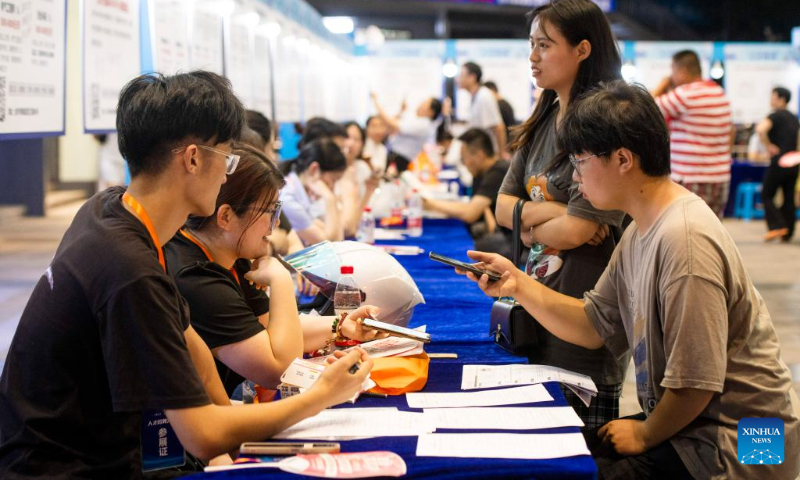 Job seekers inquire about job opportunities at a job fair for college graduates in Jinhua City, east China's Zhejiang Province, July 21, 2023. (Photo by Shi Kuanbing/Xinhua)