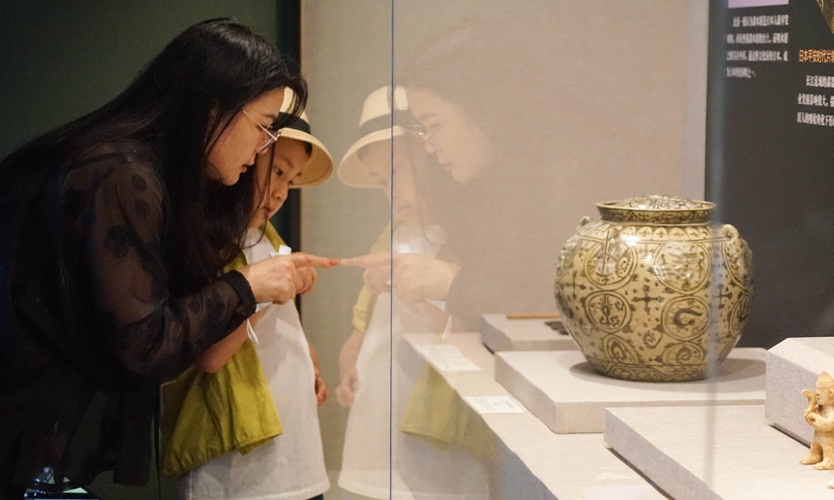 Visitors study an ancient porcelain pot at the China Maritime Museum in Shanghai, on July 10, 2023. Photo: Lu Ting/Global Times
