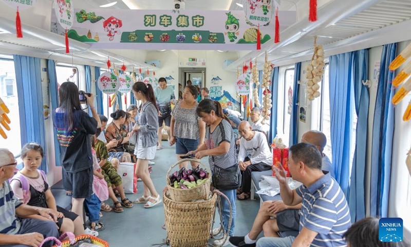 Passengers shop for local specialties on train No. 5630 from Zunyi, southwest China's Guizhou Province to southwest China's Chongqing Municipality, July 11, 2023. Trains No.5630 and 5629 are slow trains operating between Zunyi of Guizhou Province and Chongqing Municipality in southwest China.(Photo: Xinhua)