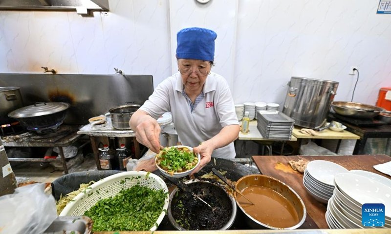 A staff worker prepares Guoba dish ingredients at a breakfast shop in the Northwest Corner of Tianjin, north China, July 11, 2023. The Northwest Corner is named due to its location in the northwest corner of the old city of Tianjin. In the morning, many tourists who speak various dialects drag their suitcases here to have breakfasts with Tianjin characteristics.(Photo: Xinhua)