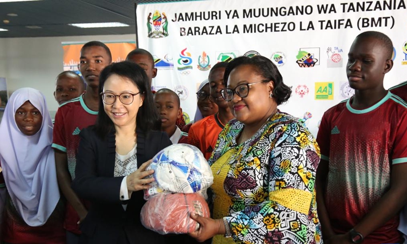 Chinese Ambassador to Tanzania Chen Mingjian and Tanzania's Minister for Culture, Arts and Sports Pindi Chana display sports equipment at the handover ceremony in Dar es Salaam, Tanzania, July 10, 2023. China on Monday donated sports equipment to Tanzania to motivate young people to develop their talents.(Photo: Xinhua)