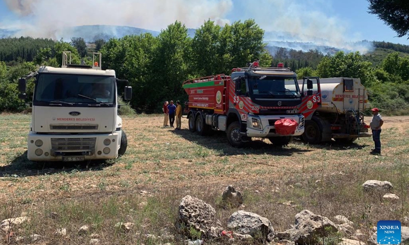 Water supply vehicles are seen near a fire in Izmir, Türkiye, on July 10, 2023. People residing in summer houses around Türkiye's Aliaga district in western Izmir province are being evacuated by land and sea after a fire broke out early Monday, the state-run TRT broadcaster reported.(Photo: Xinhua)