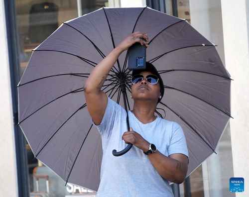 A man shelters from the sun under an umbrella in Rome, Italy, on July 10, 2023. Rome and other cities across Italy were put on red alert on Monday as the country was bracing for an intense heatwave that meteorologists said was likely to break records.(Photo: Xinhua)