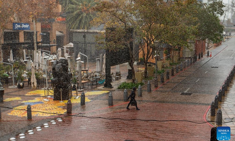 A pedestrian walks as snow falls in Melrose Arch in Johannesburg, South Africa, on July 10, 2023.(Photo: Xinhua)