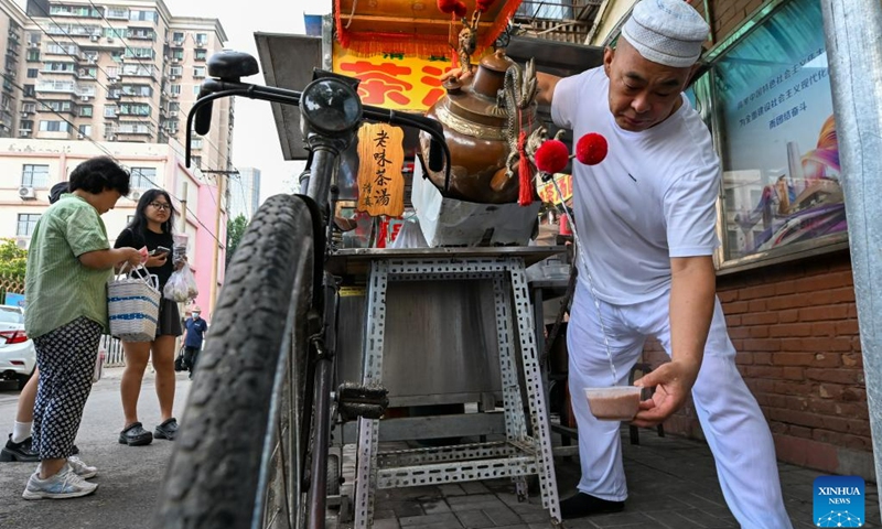 A seller makes tea soup in the Northwest Corner of Tianjin, north China, July 11, 2023. The Northwest Corner is named due to its location in the northwest corner of the old city of Tianjin. In the morning, many tourists who speak various dialects drag their suitcases here to have breakfasts with Tianjin characteristics.(Photo: Xinhua)