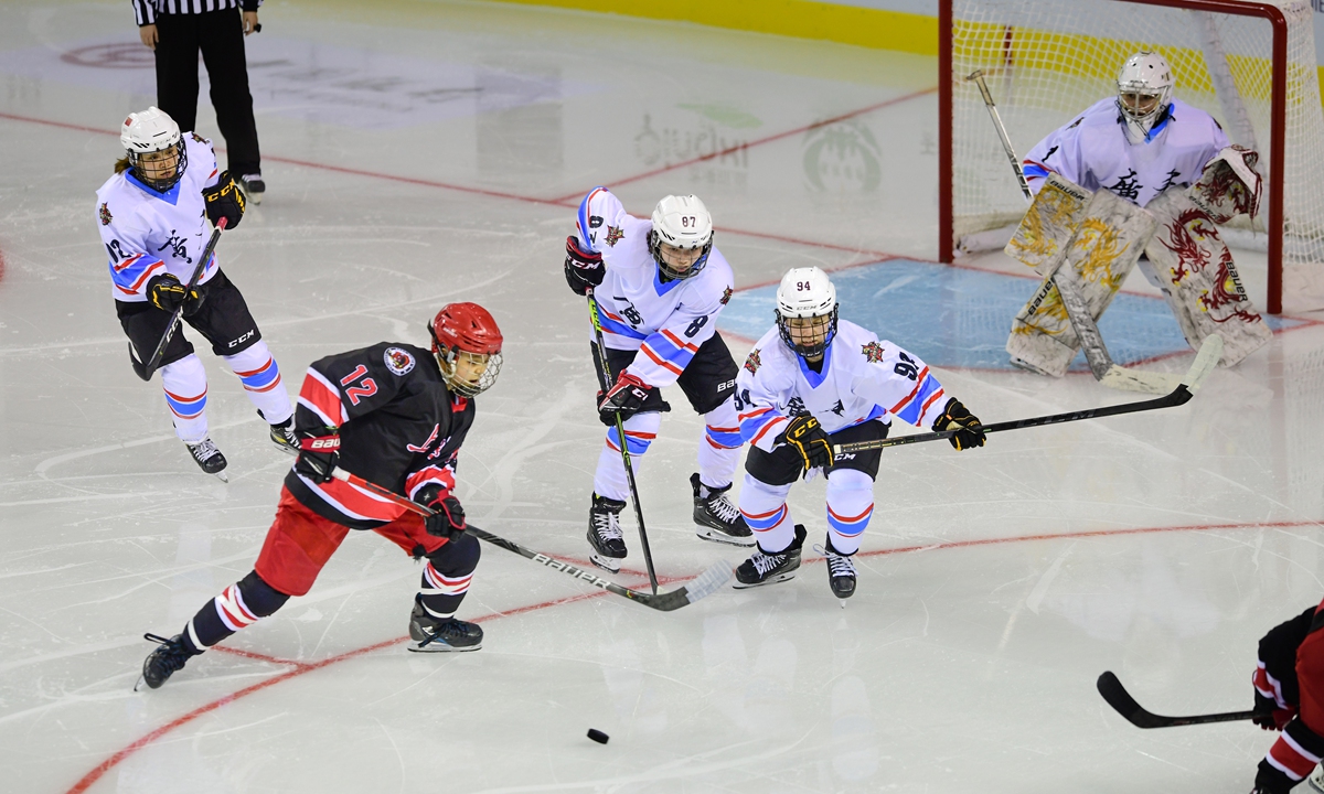 Players vie for the puck in a match between Guangdong (white) and Shanghai (black) during the women's ice hockey competition at the National Winter Games in Hulun Buir, North China's Inner Mongolia Autonomous Region on Thursday. Photo: Courtesy of the National Winter Games organizing committee
