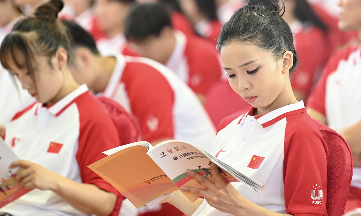 Members of the Chinese university sports delegation for the 31st Chengdu Universiade read materials related to the event in Changchun, Jilin Province, on July 12, 2023. Photo: VCG