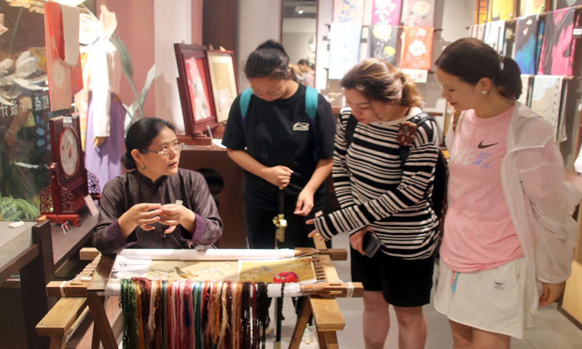 Tourists appreciate the Suzhou embroidery at Pingjiang Historic and Cultural Block in Suzhou, East China's Jiangsu Province, on July 10, 2023. Photo: IC