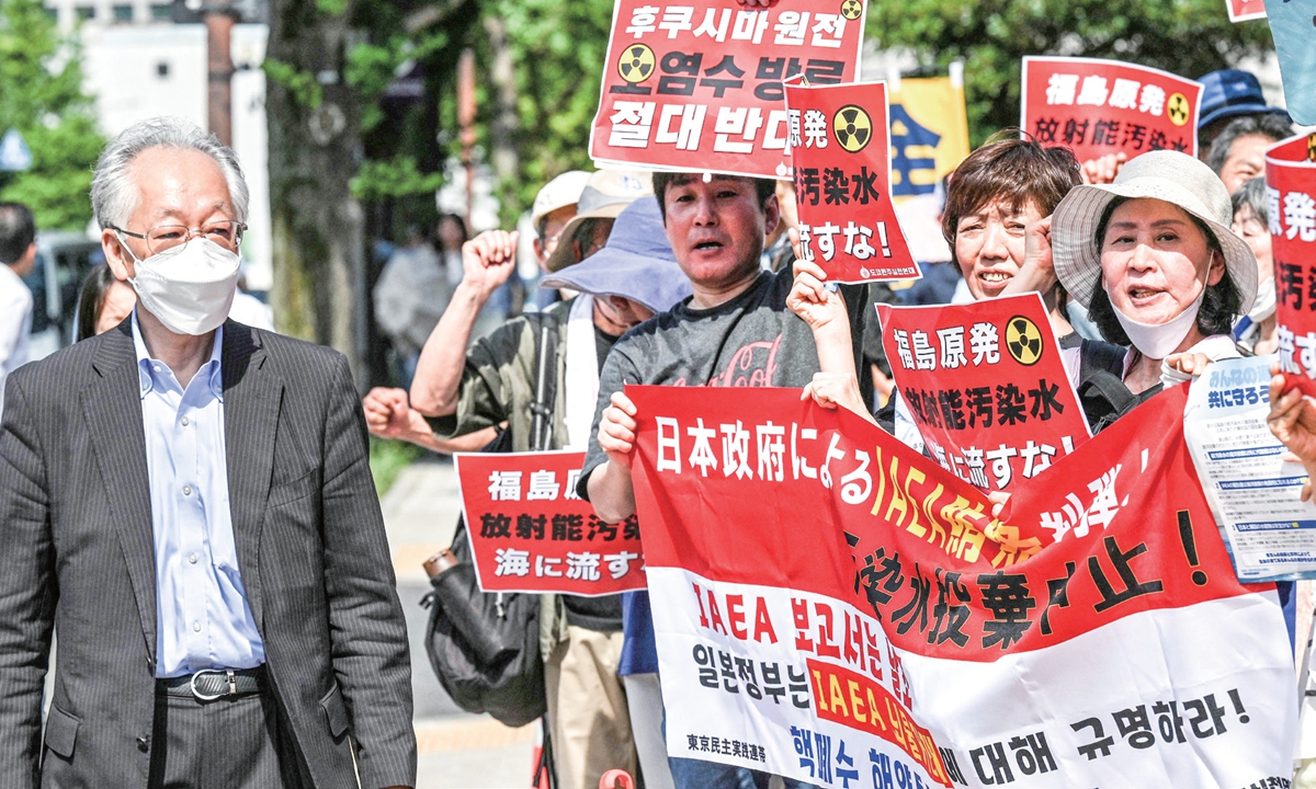 A man walks past as protesters, including South Korean activists, take part in a rally to protest against the Japanese government's plan to dump Fukushima nuclear-contaminated wastewater into the Pacifi c Ocean, outside Japan's prime minister's o ce in Tokyo on July 12, 2023. Photo: VCG