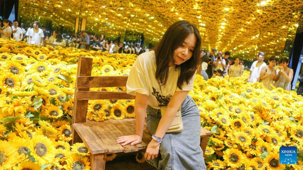 A visitor poses for photos during the immersive exhibition Van Gogh Alive: the experience at the World Expo Museum at night in Shanghai, east China, July 16, 2023. The World Expo Museum in east China's Shanghai extends its opening hours on every Friday, Saturday, Sunday and holidays from May 12 to Sept. 10, 2023.(Photo: Xinhua)