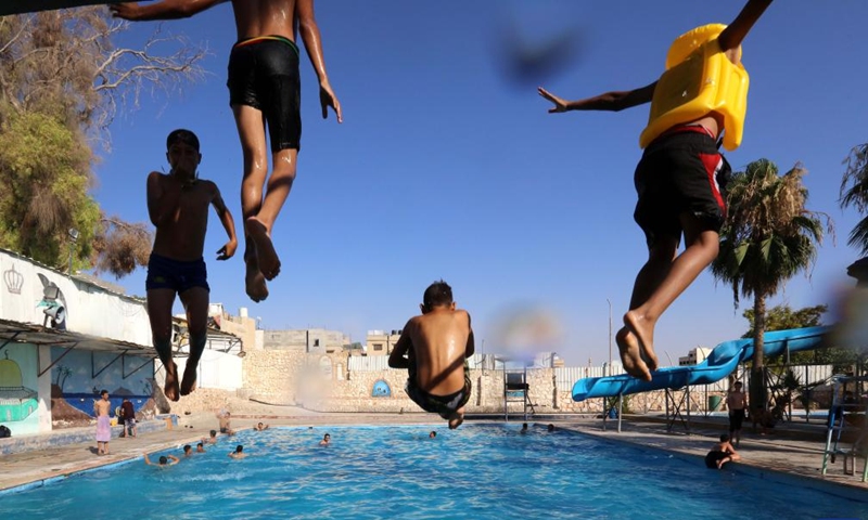 People dive into a swimming pool during a heat wave in Zarqa, east of Amman, Jordan, on July 12, 2023.(Photo: Xinhua)