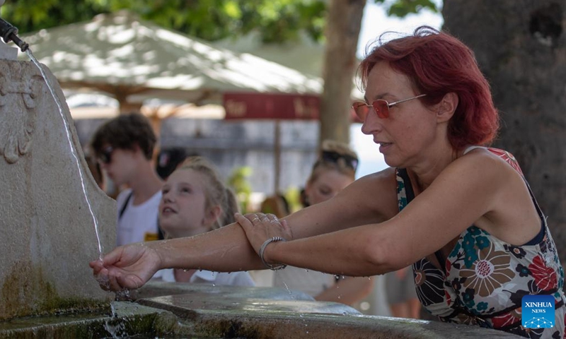 A tourist cools herself off in Dubrovnik, Croatia, July 12, 2023.(Photo: Xinhua)