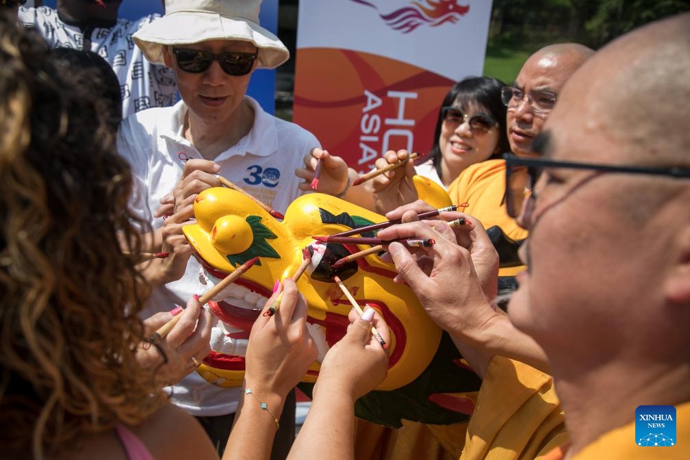 People dot the eyes of a dragon boat during a dragon eye dotting ceremony of Hong Kong Dragon Boat Festival in Central Park in New York, the United States, on July 20, 2023. A dragon eye dotting ceremony was held in New York City, the United States, on Thursday as a prelude to the 2023 Hong Kong Dragon Boat Festival, which is scheduled for next month.(Photo: Xinhua)