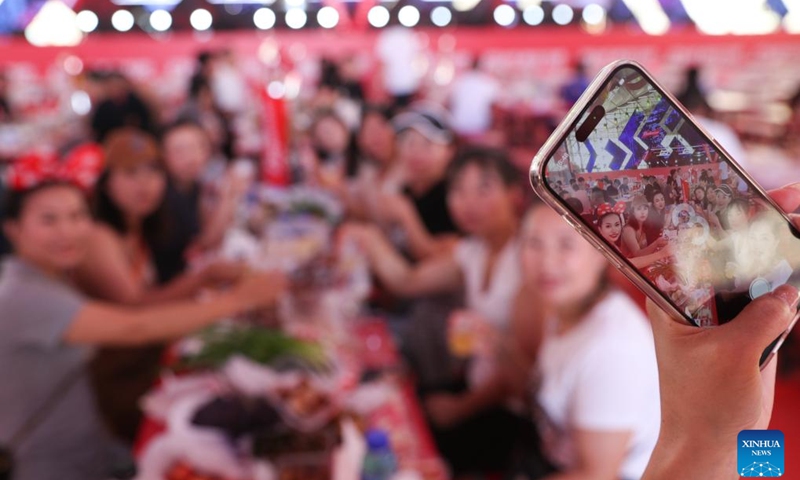 Visitors pose for photos at the 21th China Harbin International Beer Festival in Harbin, capital of northeast China's Heilongjiang Province, July 20, 2023. The 21th China Harbin International Beer Festival opened here on Thursday.(Photo: Xinhua)