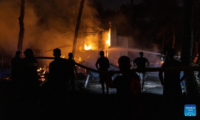 People try to put out a wildfire that burned a house in Mandra, a western suburb of Athens, Greece, July 18, 2023. Hundreds of Greek firefighters continued for a second day on Tuesday to battle two major wildfires near Dervenochoria, some 30 km northwest of Athens, and near the seaside resort of Loutraki, about 80 km southwest of the capital, authorities said.(Photo: Xinhua)