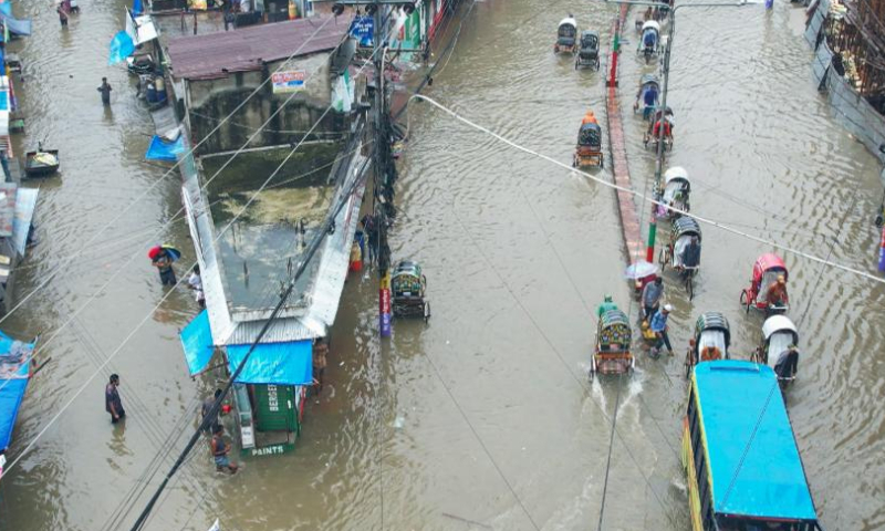 Vehicles drive on a water-logged road in Chattogram, Bangladesh, Aug. 6, 2023. Days of torrential rain lashed the Bangladesh's seaport city Chattogram, some 242 km southeast of capital Dhaka, inundating low-lying areas and disrupting road traffic. (Xinhua)