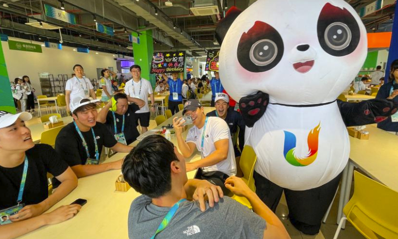 A dining centre staff member dressed as the mascot Rongbao celebrates the birthday of South Korea's players in the 31st FISU Summer World University Games Village in Chengdu, southwest China's Sichuan Province, July 30, 2023. (Xinhua/Shen Bohan)
