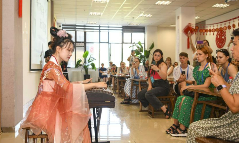 Foreign dance troupe members watch a performance of guzheng, a Chinese zither, at the Xinjiang Library in Urumqi, northwest China's Xinjiang Uygur Autonomous Region, on July 23, 2023.

Themed Dreams of Dance, Harmony of Silk Road, the 6th China Xinjiang International Dance Festival has attracted over 1,000 artists from countries and regions in Asia, Europe and Africa, and they are expected to stage some 60 well-known performances. (Xinhua/Hu Huhu)