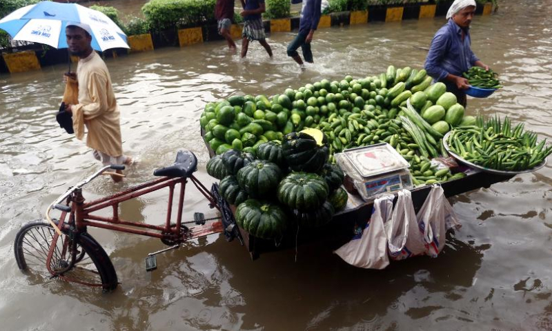 A vendor sells vegetables from a rickshaw van in a waterlogged street in Chattogram, Bangladesh, Aug. 6, 2023. Days of torrential rain lashed the Bangladesh's seaport city Chattogram, some 242 km southeast of capital Dhaka, inundating low-lying areas and disrupting road traffic. (Xinhua)