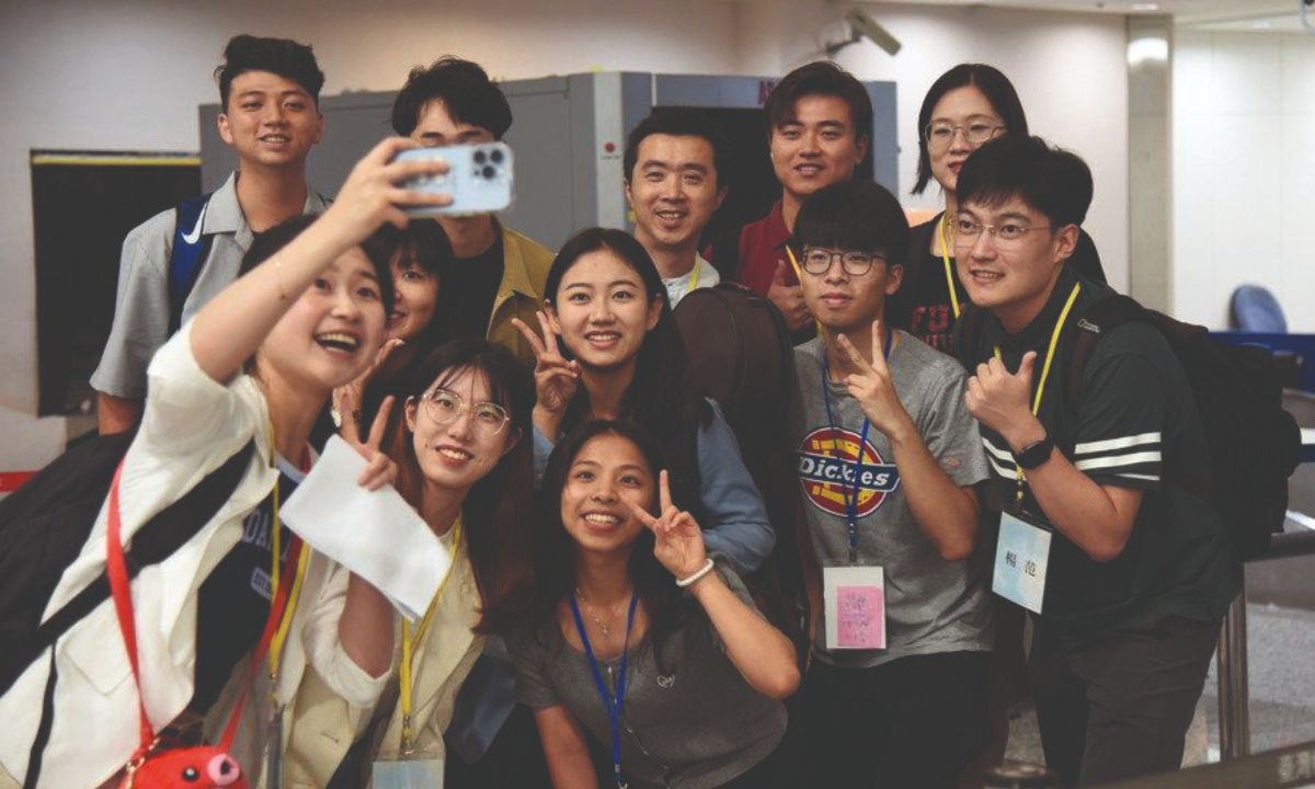 Students from the Chinese mainland who are about to conclude their exchange trip take a group photo with students from the island of Taiwan in Taoyuan International Airport on July 23, 2023. Photo: Xinhua 