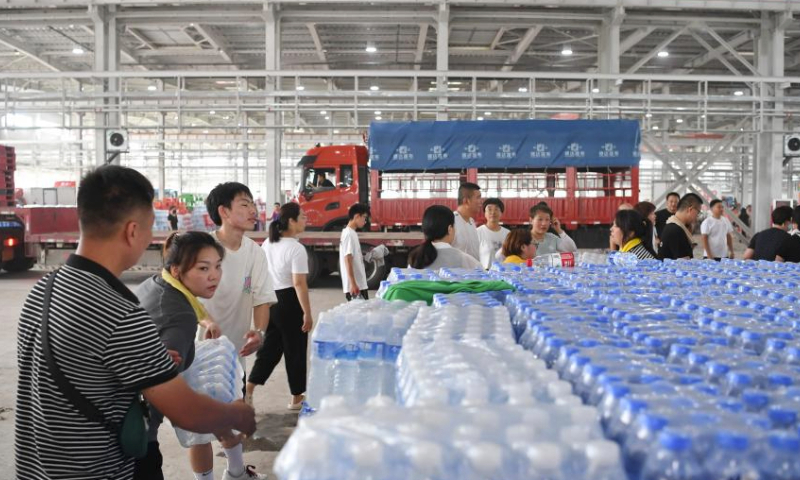 Staff members and volunteers transfer the donated relief supplies at a storage site of relief supplies in Zhuozhou, north China's Hebei Province, Aug. 5, 2023. A large number of donated relief supplies from all over the country arrived in Zhuozhou on Saturday, supporting local people affected by rainstorms and floods. (Xinhua/Mu Yu)