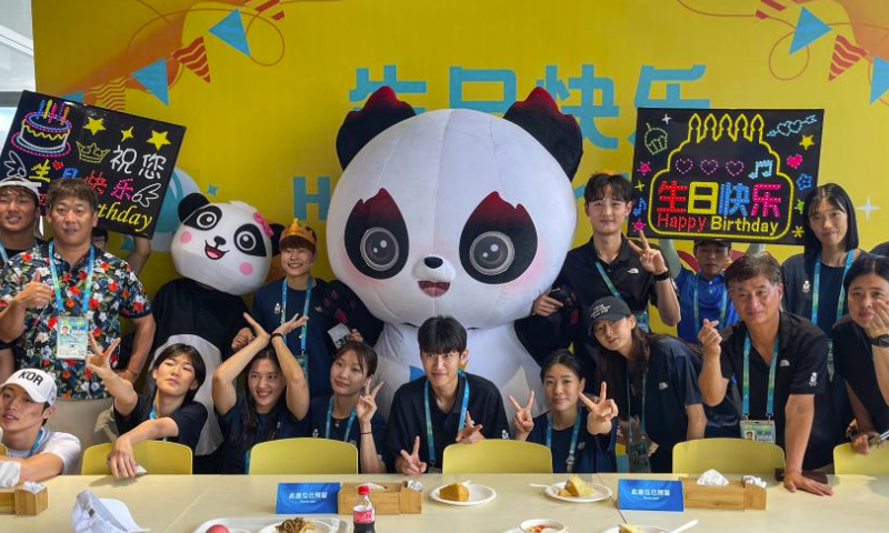 Water polo player Lee Sideok (Rear, 4th R) of South Korea and taekwondo player Park Hyejin (Rear, 6th R) of South Korea attend their birthday party at the dining centre in the 31st FISU Summer World University Games Village in Chengdu, southwest China's Sichuan Province, July 30, 2023. (Xinhua/Shen Bohan)