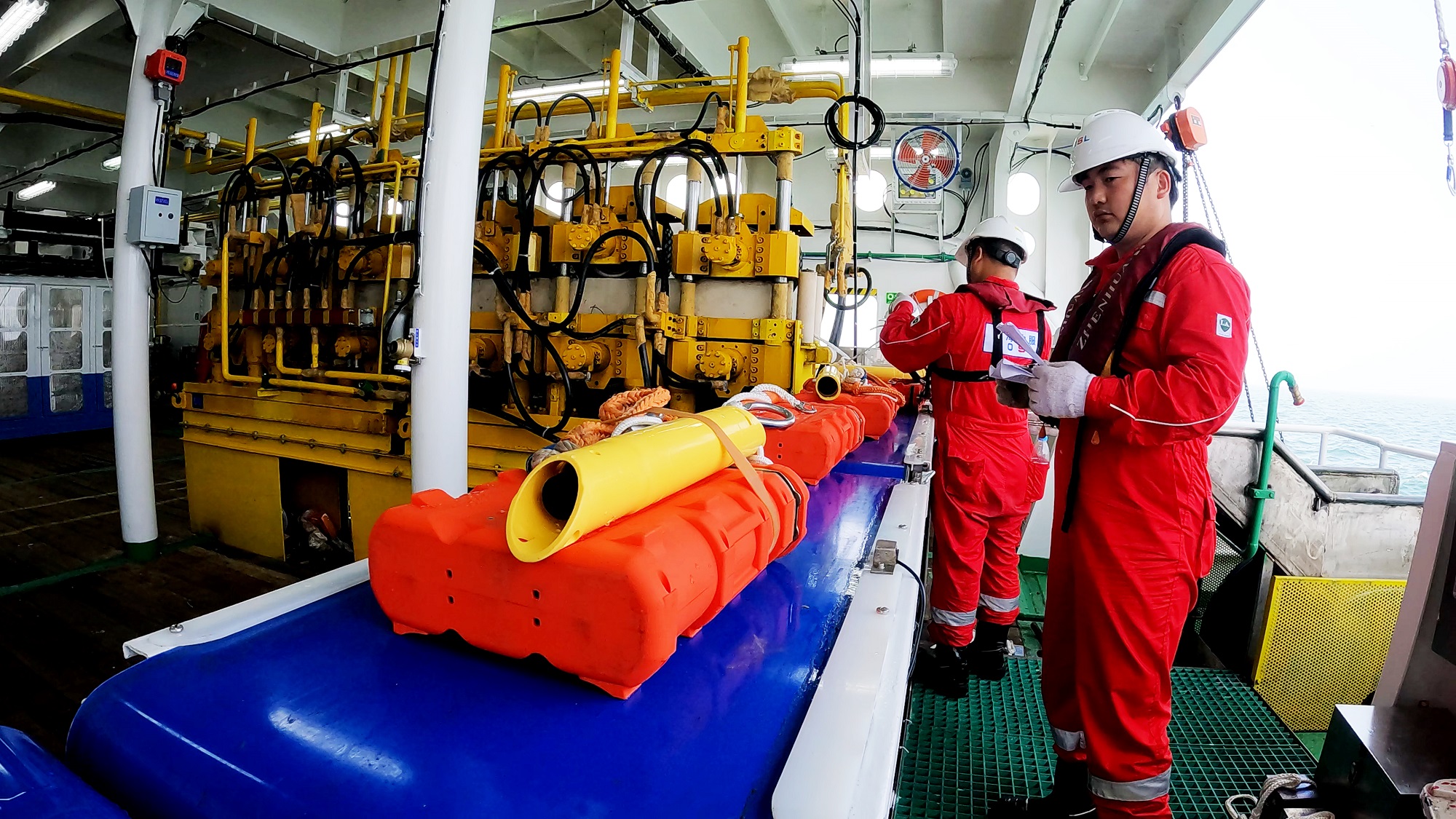 Technical staff handle marine seismic exploration and acquisition equipment. Photo: Courtesy of the China National Offshore Oil Corporation