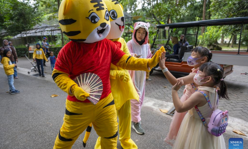 Performers in tiger-figured costumes interact with visitors at Zoo Negara, the national zoo of Malaysia, in Kuala Lumpur, Malaysia, on July 29, 2023. The International Tiger Day is marked on July 29 every year. (Photo by Chong Voon Chung/Xinhua)