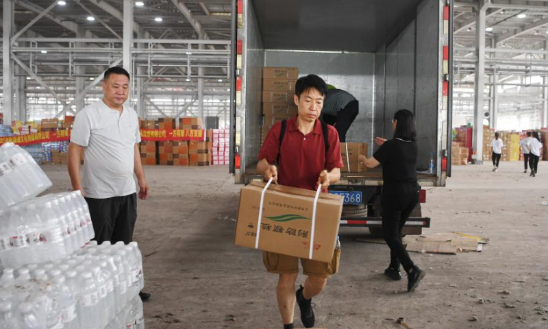 Volunteers from China Charity Federation transfer the donated relief supplies at a storage site of relief supplies in Zhuozhou, north China's Hebei Province, Aug. 5, 2023. A large number of donated relief supplies from all over the country arrived in Zhuozhou on Saturday, supporting local people affected by rainstorms and floods. (Xinhua/Mu Yu)