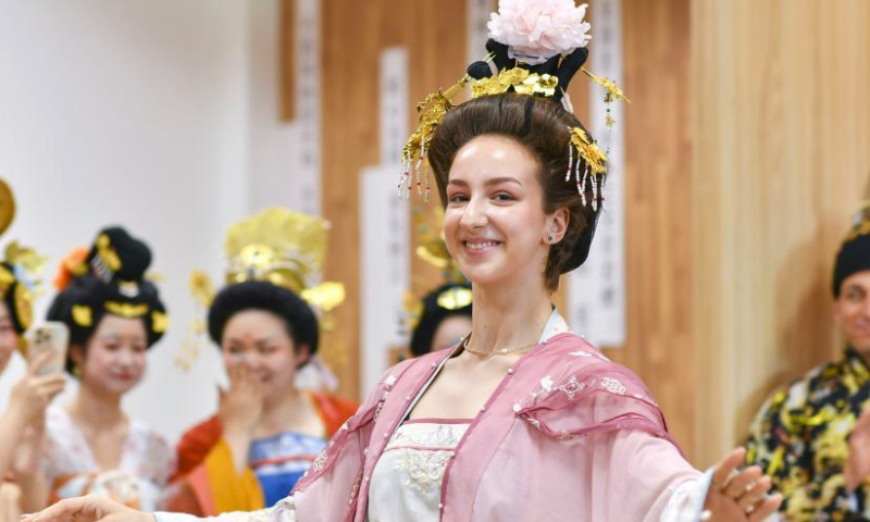 Sofia tries a traditional Chinese costume at the Xinjiang Library in Urumqi, capital of northwest China's Xinjiang Uygur Autonomous Region, on July 23, 2023. This is an unforgettable tour of Xinjiang - wondrous! said Sofia Maksimovna Efremenko, a young Russian dancer who has spent a pleasant week here.

A member of the song and dance ensemble Zorenka of Balashov City, Saratov Oblast of Russia, Sofia came along with more than 1,000 of her counterparts from Asia, Europe and Africa for the 6th China Xinjiang International Dance Festival being held from July 20 to Aug. 5.

Besides their performance on stage, Sofia and her colleagues visited places of interest in Urumqi for a profound experience of the Chinese culture, particularly the traditions in Xinjiang. I'll definitely come again. (Xinhua/Hu Huhu)