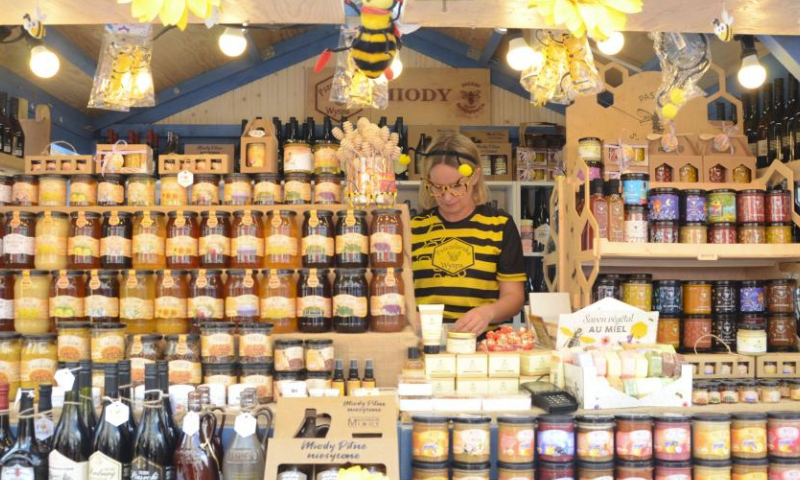 A woman dressed in costume sells honey at St. Dominic's Fair in Gdansk, Poland, July 30, 2023. The St. Dominic's Fair is held in Poland's port city of Gdansk from July 22 to Aug. 13 this year. (Xinhua/Chen Chen)