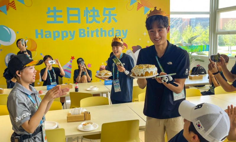 Water polo player Lee Sideok (3rd R) of South Korea and taekwondo player Park Hyejin (4th R) of South Korea receive birthday cakes from dining centre's staff member in the 31st FISU Summer World University Games Village in Chengdu, southwest China's Sichuan Province, July 30, 2023. (Xinhua/Shen Bohan)