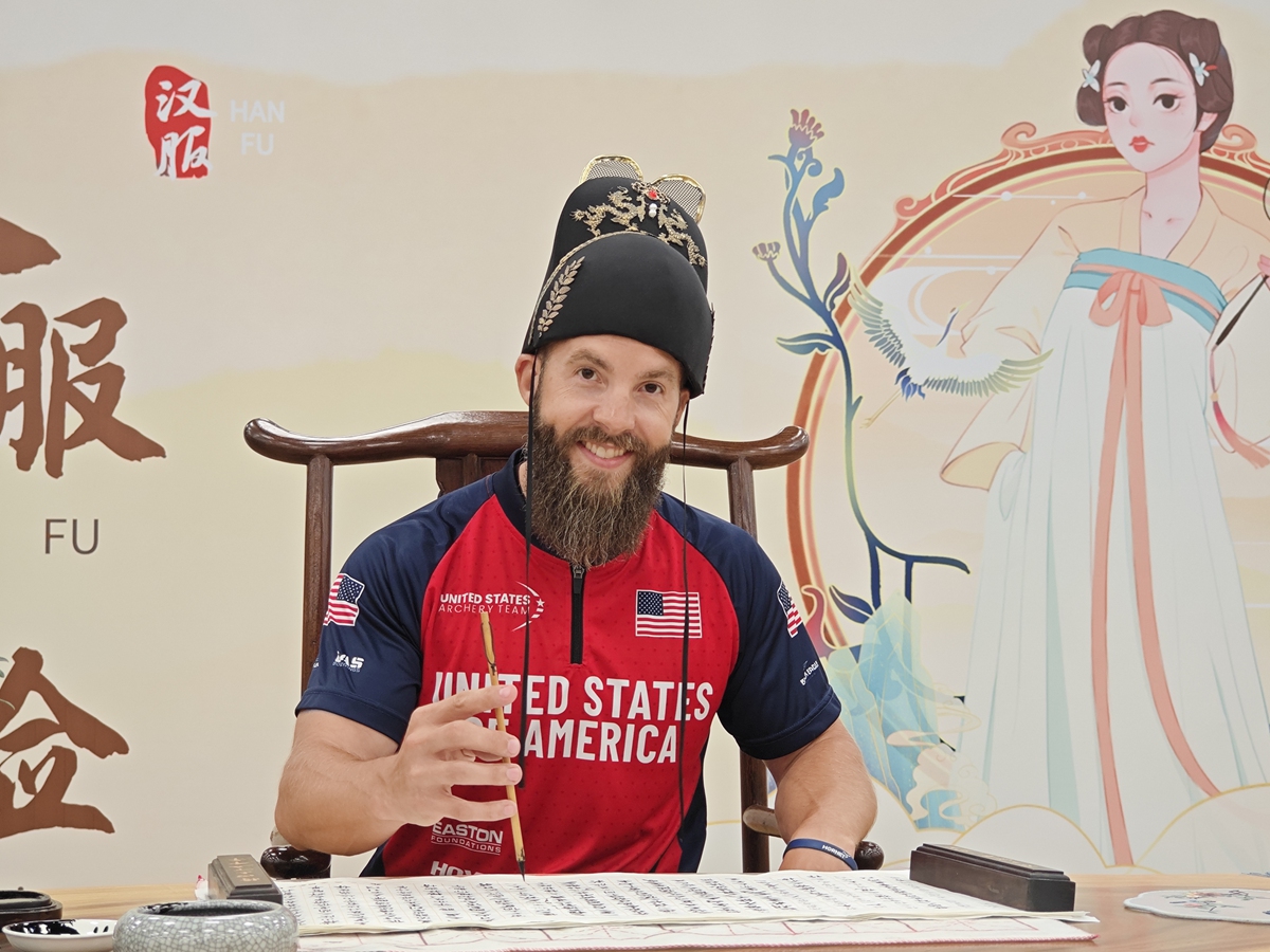 An athlete from the US archery team practices Chinese calligraphy at the FISU Games Village in Chengdu, Southwest China's Sichuan Province, on July 31, 2023. Various programs are held in the village for foreign athletes and coaches to experience traditional Chinese culture, such as shadow puppetry, rope weaving, kite making, paper cutting, Hanfu (a traditional Chinese outfit) and Chinese calligraphy. Photo: Chen Tao/Global Times