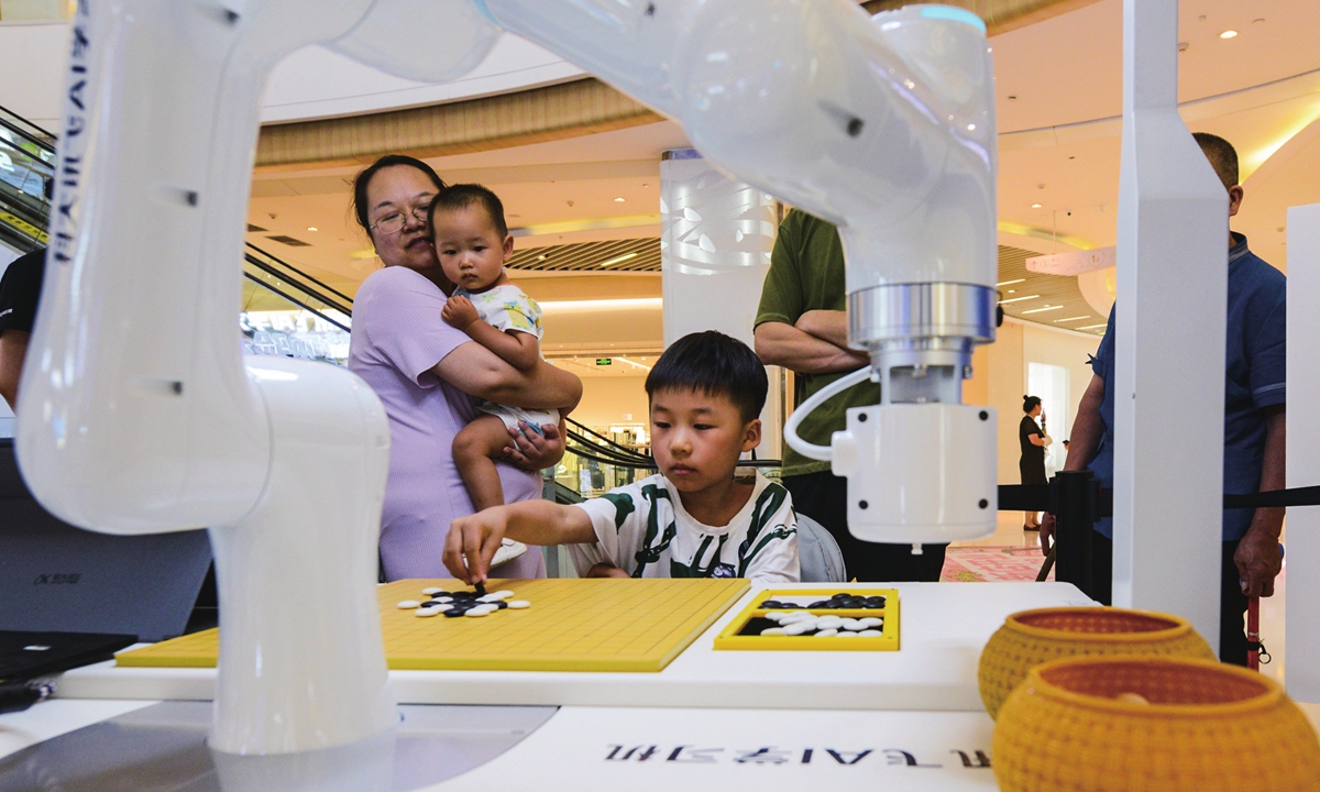 A child plays backgammon with a robot at a shopping center in Zhengzhou, Central China's Henan Province on July 31, 2023. Many provinces across the country have integrated artificial intelligence (AI) into the education of young students, an effort to nurture up-to-date AI talent. Photo: VCG