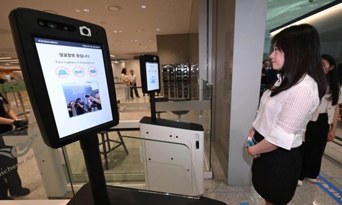 An Incheon airport official demonstrates the use of the facial recognition Smart pass service at a departure gate of Terminal 2, Incheon International Airport, Friday. The paperless biometrics system allows passengers to go through departure and boarding gates without having to show their passports and boarding passes. Korea Times photo by Shim Hyun-chul