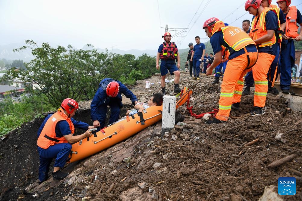 Rescuers transfer an injured villager in Shuiyuzui Village in flood-hit Mentougou District, Beijing, capital of China, Aug. 1, 2023. Several districts in the city, including the hardest-hit Fangshan and Mentougou, maintained the highest-level alert for flood control on Tuesday, as downpours will continue, the city's flood control authorities said.(Photo: Xinhua)