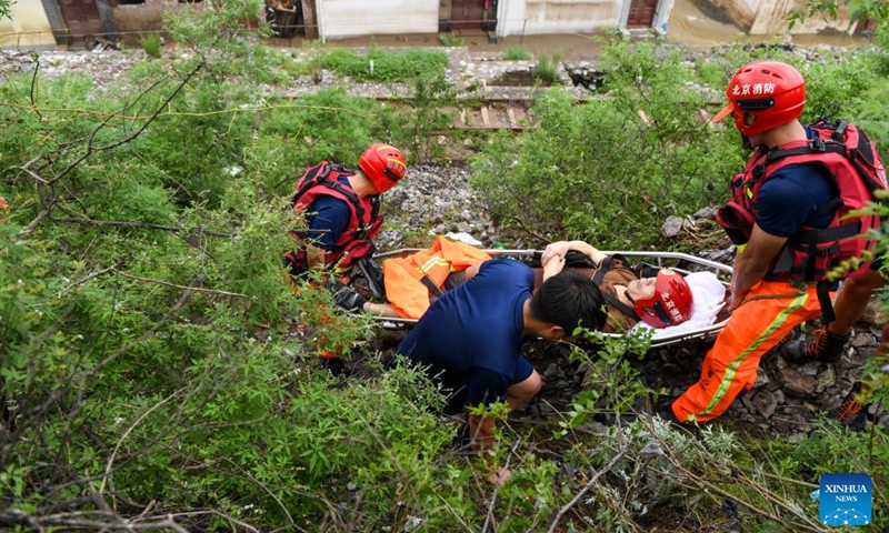 Rescuers transfer an injured villager in Shuiyuzui Village in flood-hit Mentougou District, Beijing, capital of China, Aug. 1, 2023. Several districts in the city, including the hardest-hit Fangshan and Mentougou, maintained the highest-level alert for flood control on Tuesday, as downpours will continue, the city's flood control authorities said.(Photo: Xinhua)