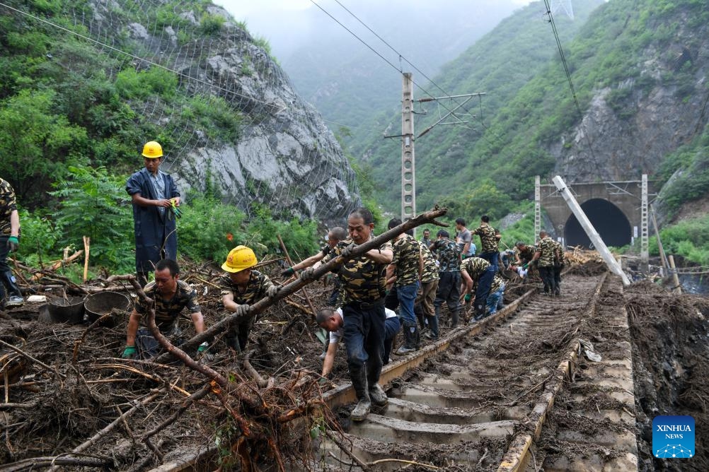 Railway workers remove fallen trees from railway tracks in Shuiyuzui Village in flood-hit Mentougou District, Beijing, capital of China, Aug. 1, 2023. Several districts in the city, including the hardest-hit Fangshan and Mentougou, maintained the highest-level alert for flood control on Tuesday, as downpours will continue, the city's flood control authorities said.(Photo: Xinhua)