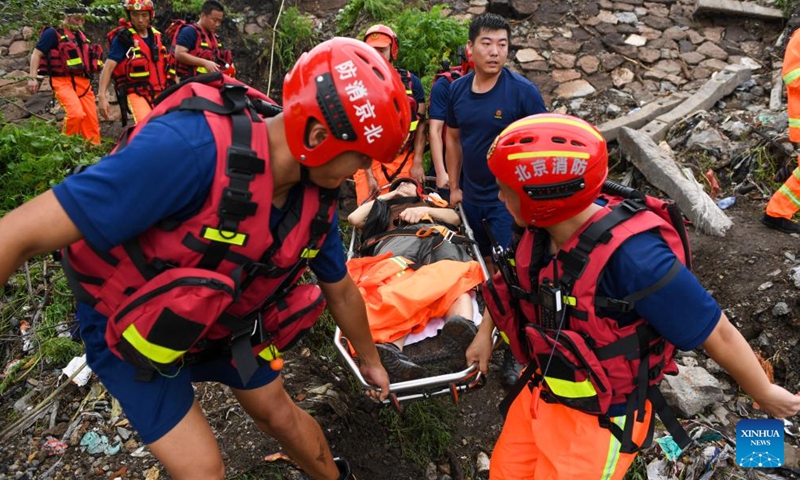 Rescuers transfer an injured villager in Shuiyuzui Village in flood-hit Mentougou District, Beijing, capital of China, Aug. 1, 2023. Several districts in the city, including the hardest-hit Fangshan and Mentougou, maintained the highest-level alert for flood control on Tuesday, as downpours will continue, the city's flood control authorities said.(Photo: Xinhua)