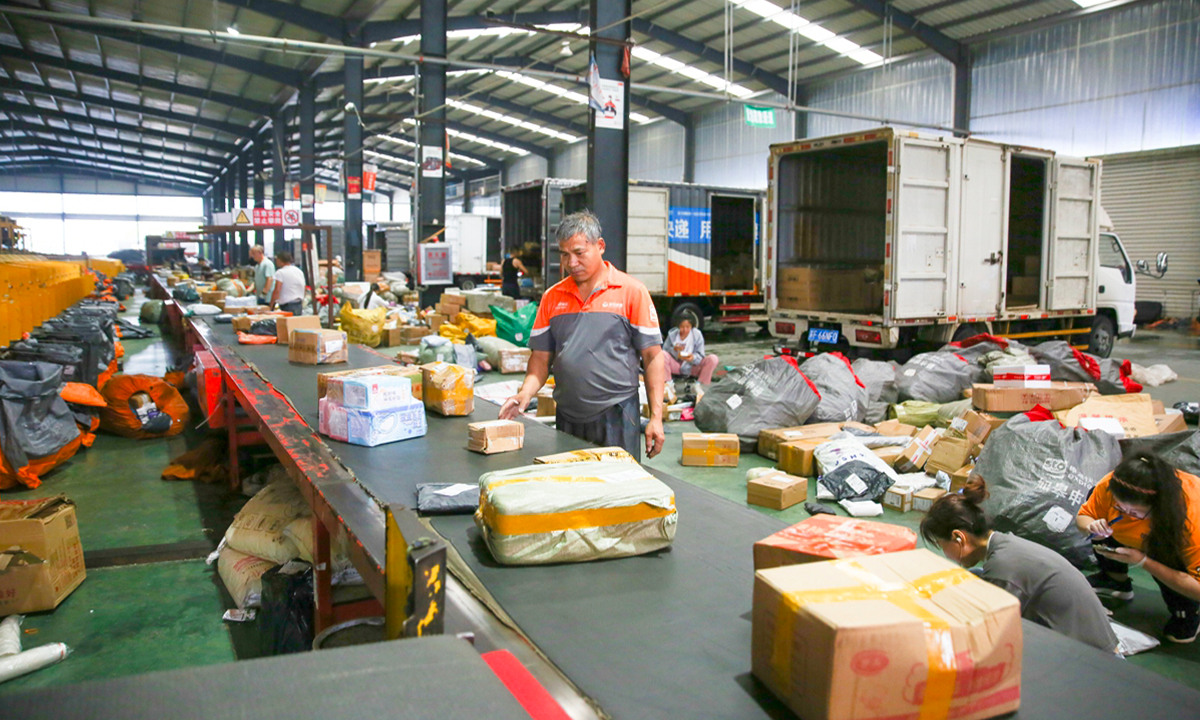 Staff members are busy packing and sorting parcels for the 618 shopping festival on June 18, 2023, at a logistics park in Nantong, East China's Jiangsu Province. Photo: VCG

