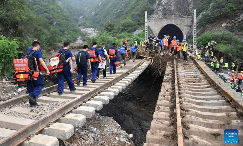 Rescuers walk to transfer stranded passengers in Mentougou District of Beijing, capital of China, Aug. 2, 2023. The last batch of stranded passengers of trains Z180 and K396 arrived at the Fengtai Railway Station in Beijing early in the morning on Aug. 3. By far, all the passengers of trains K396, Z180 and K1178 stranded due to the heavy rainfall have been safely evacuated from mountainous areas of Mentougou in Beijing.(Photo: Xinhua)