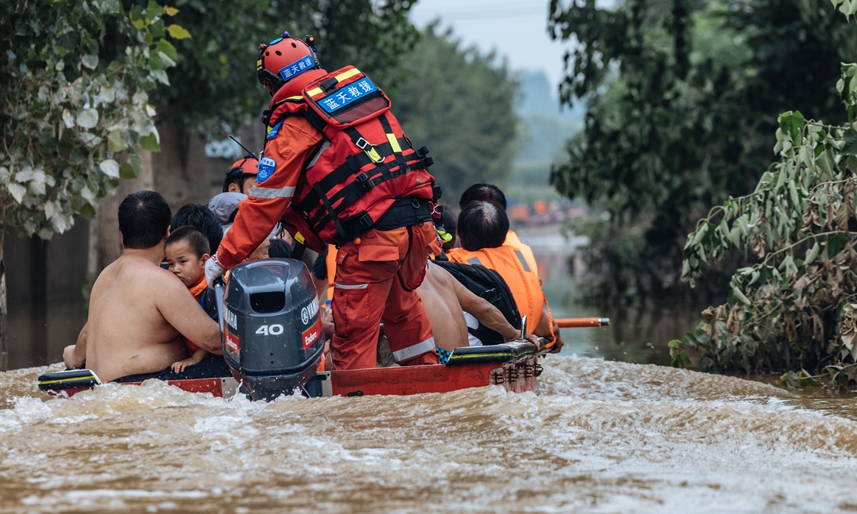 Members of the Blue Sky rescue team transport flood-affected residents and supplies in Huangjiajie village and Mengjiajie village in Matou township, Zhuozhou, North China's Hebei Province, on August 3, 2023. Photo:Li Hao/GT