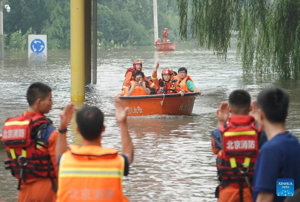 People take a rescue boat to a transshipment point in Fangshan District of Beijing, capital of China, Aug. 2, 2023. Some parts of the Fangshan District suffered from flood and geological disasters caused by recent rainstorms in the capital city. A rescue team comprised of firefighters, medical workers and volunteers set out to evacuate people afflicted by rainstorms and floods in Pinggezhuang Village of Liulihe Town on Wednesday. (Photo: Xinhua)